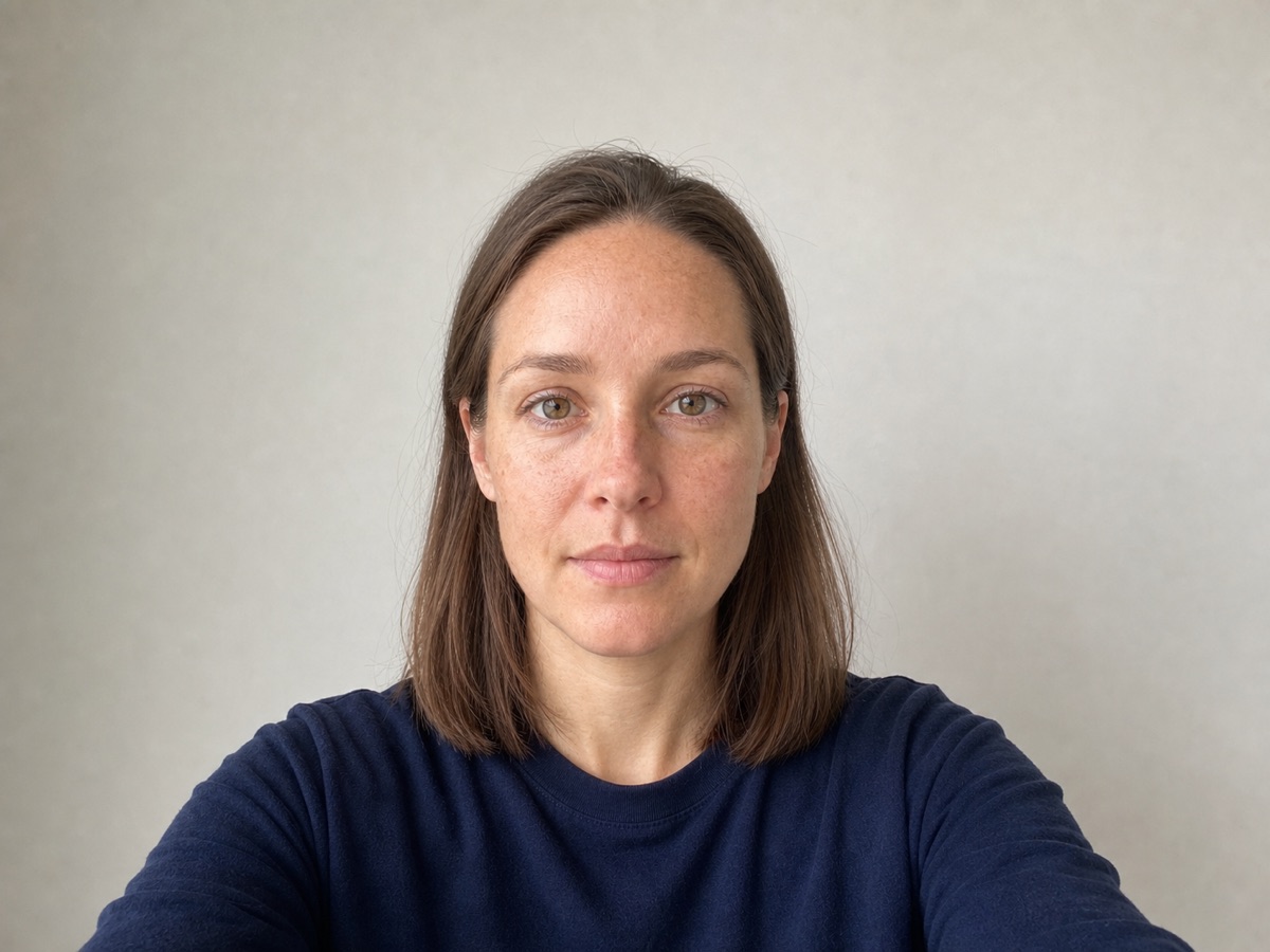 A centred front-facing phone selfie with the head level and shoulders square